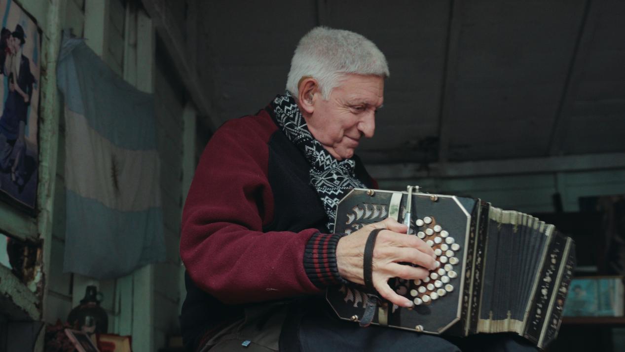 街头艺人诺尔贝托正在弹奏班多钮手风琴。记者张若涵 摄