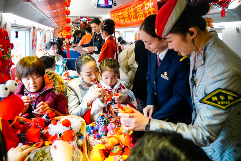 在青岛北开往青岛北的G6955次环线列车上，旅客在列车上体验布偶缝制。王敏摄
